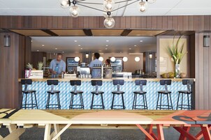 Ein Restaurant mit Barbereich, mehreren Barhocker und einer Theke.