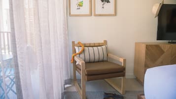 Ein Hotelzimmer mit einem Holzbett, einem Fernseher und zwei gerahmten Bildern an der Wand.