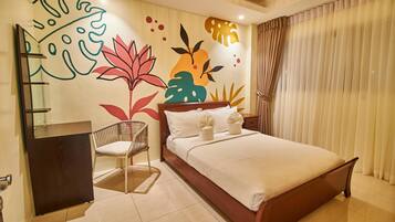 Un dormitorio moderno con una cama de madera, una silla, un escritorio pequeño y un mural en la pared.