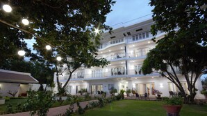 Un hôtel à plusieurs étages doté de balcons, d’un jardin bien entretenu et d’espaces extérieurs aménagés pour se détendre.
