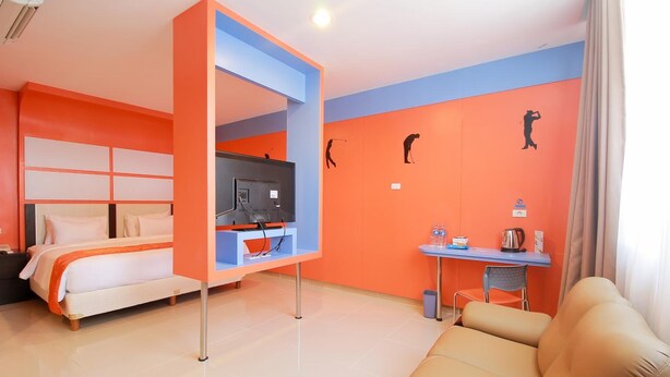 Una camera d'albergo con un letto, una televisione, una scrivania e un divano.