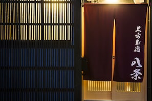 A traditional Japanese building entrance with a sliding door and a sign with Japanese characters.