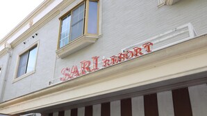 Un edificio con un letrero que dice 'SARI RESORT'.