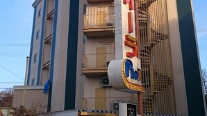 Ein Hotel mit auffälliger Beschilderung, mehreren Balkonen und modernem architektonischen Design.