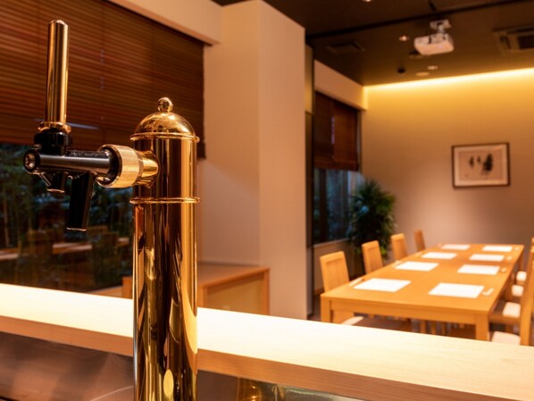 Un interior moderno con grifo metálico, muebles de madera y una mesa de conferencias.