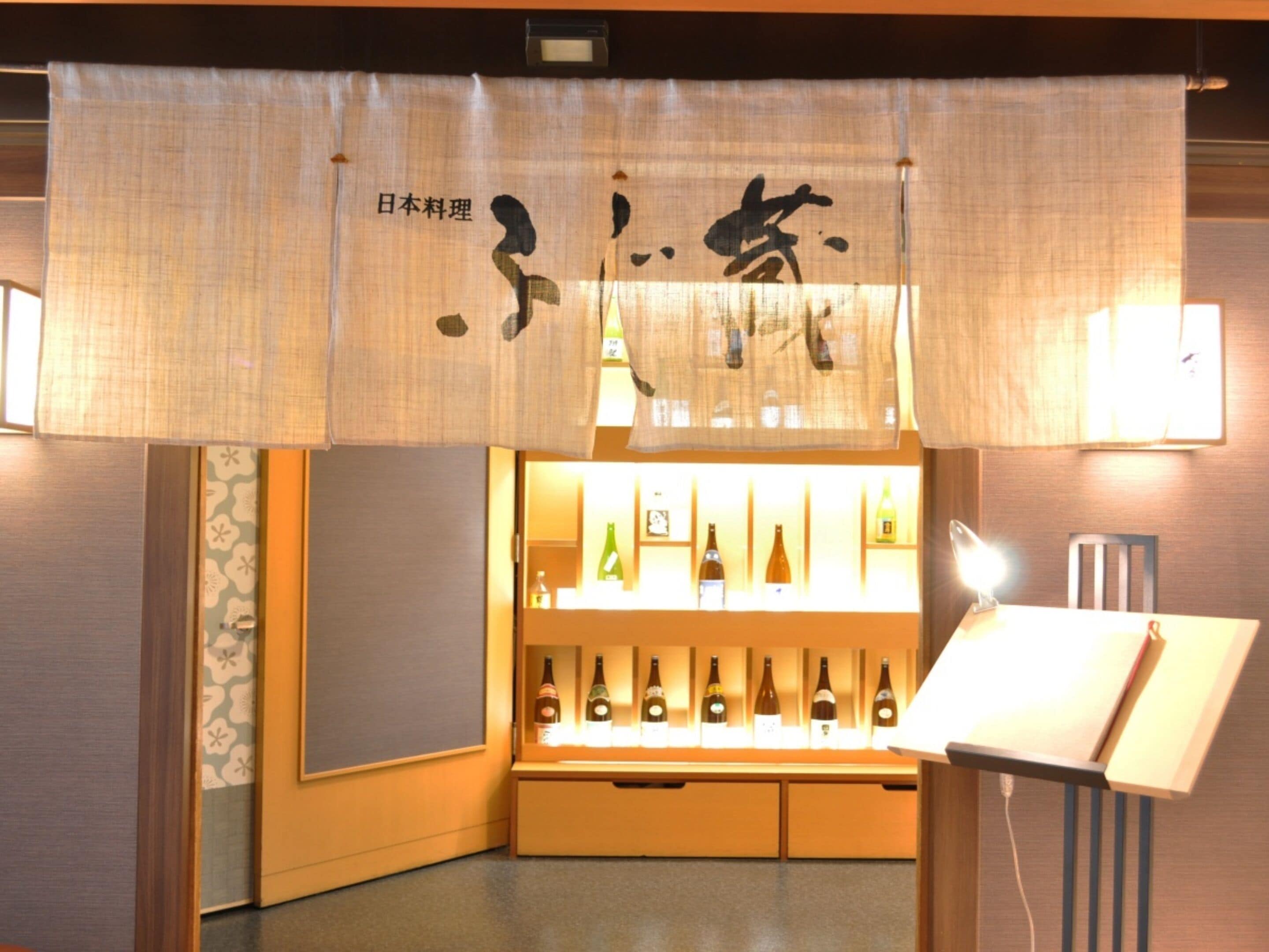Una habitación tradicional japonesa con un aparador de madera que exhibe botellas, una pantalla shoji colgante y una lámpara.