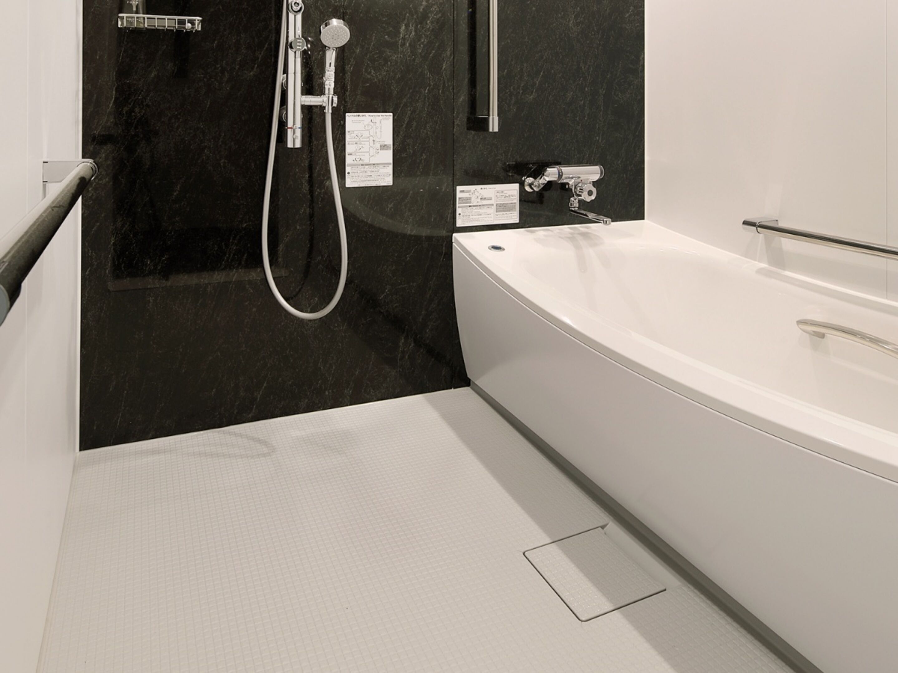 Un baño moderno con una bañera grande, una zona de ducha y suelo de baldosas.