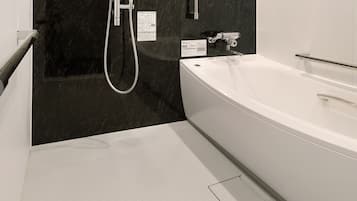Un baño moderno con una bañera grande, una zona de ducha y suelo de baldosas.
