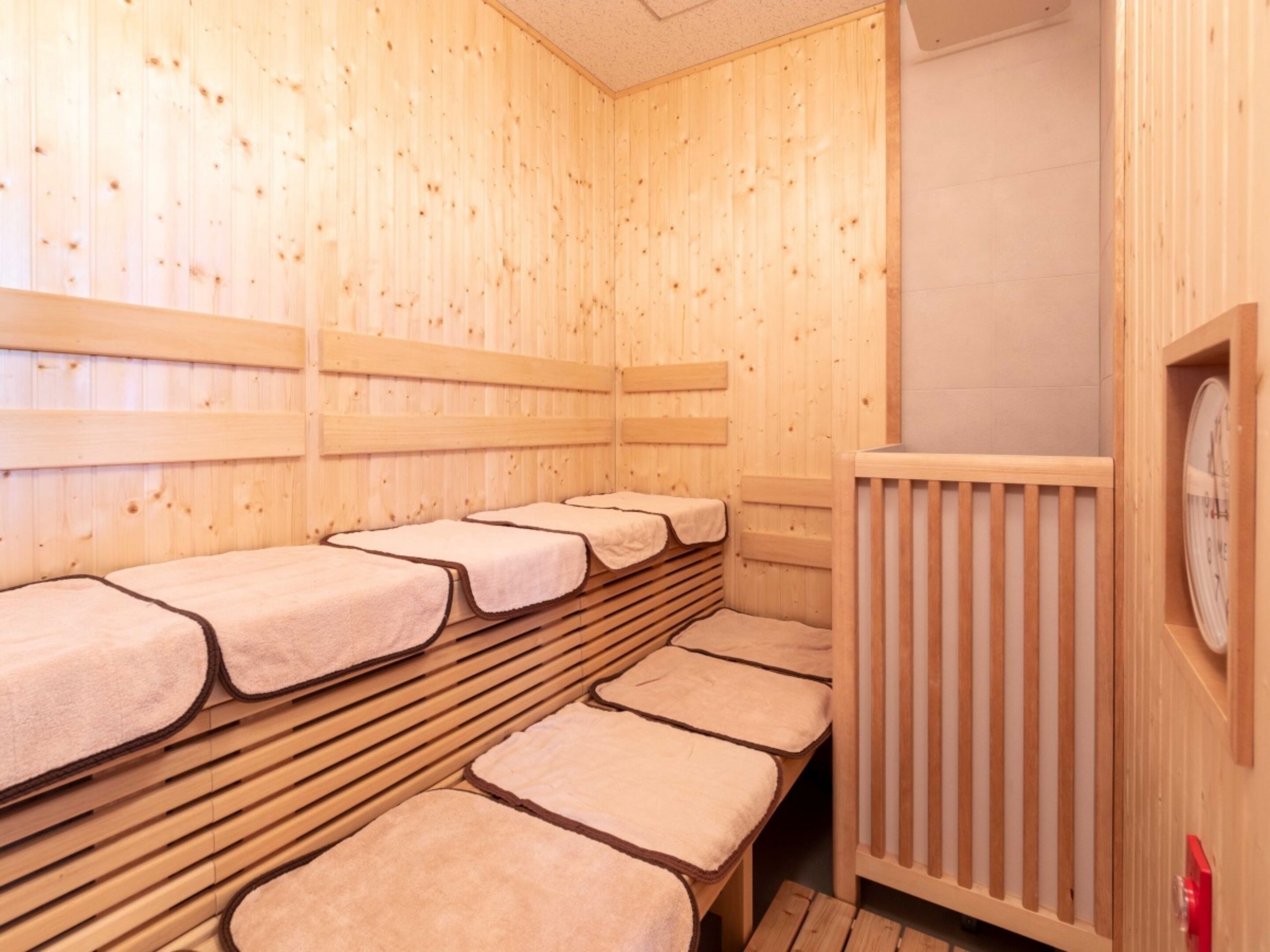 A sauna room with wooden benches and a wooden wall.