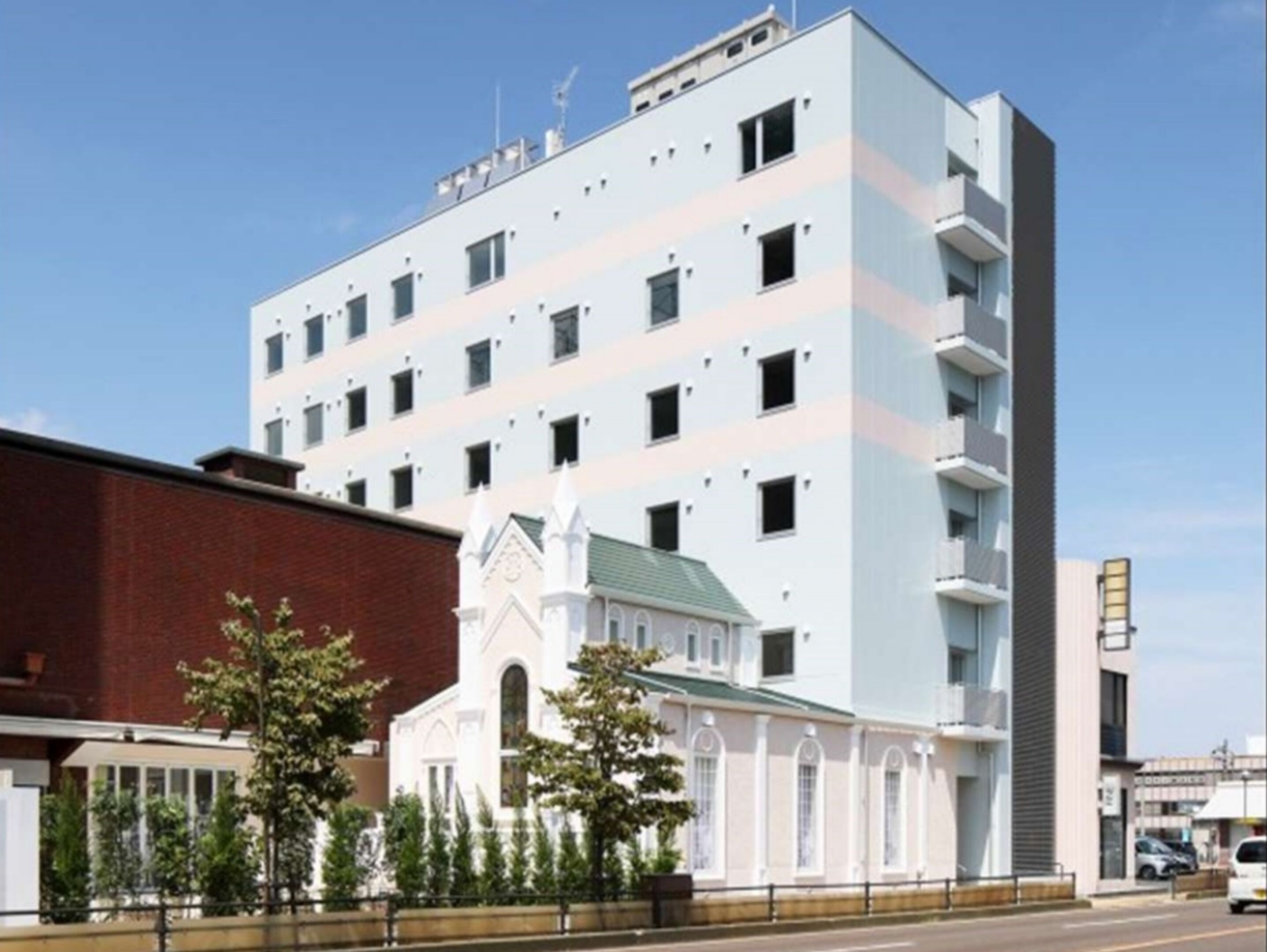Un edificio de varios pisos con un diseño moderno, que presenta una combinación de ventanas rectangulares y cuadradas.