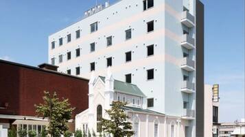 Un edificio de varios pisos con un diseño moderno, que presenta una combinación de ventanas rectangulares y cuadradas.