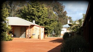 A rural property with a large open area, a brick building with a garage, and a house with a tiled roof. - York Motel (York)