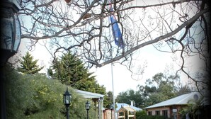 A garden area with a bench, a gazebo, and a pathway. - York Motel (York)