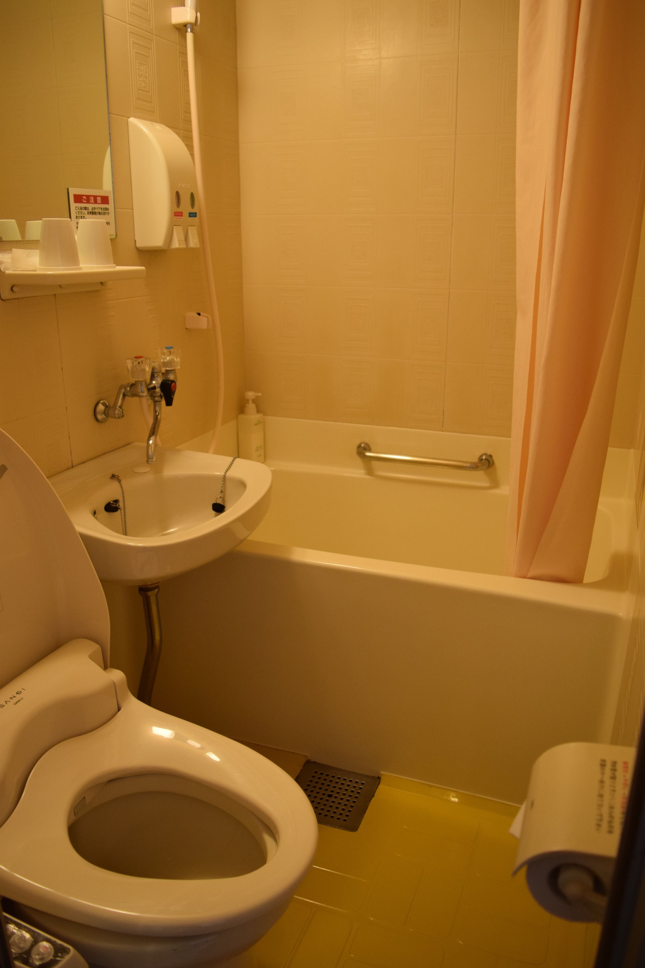 A bathroom with a toilet, sink, and bathtub.