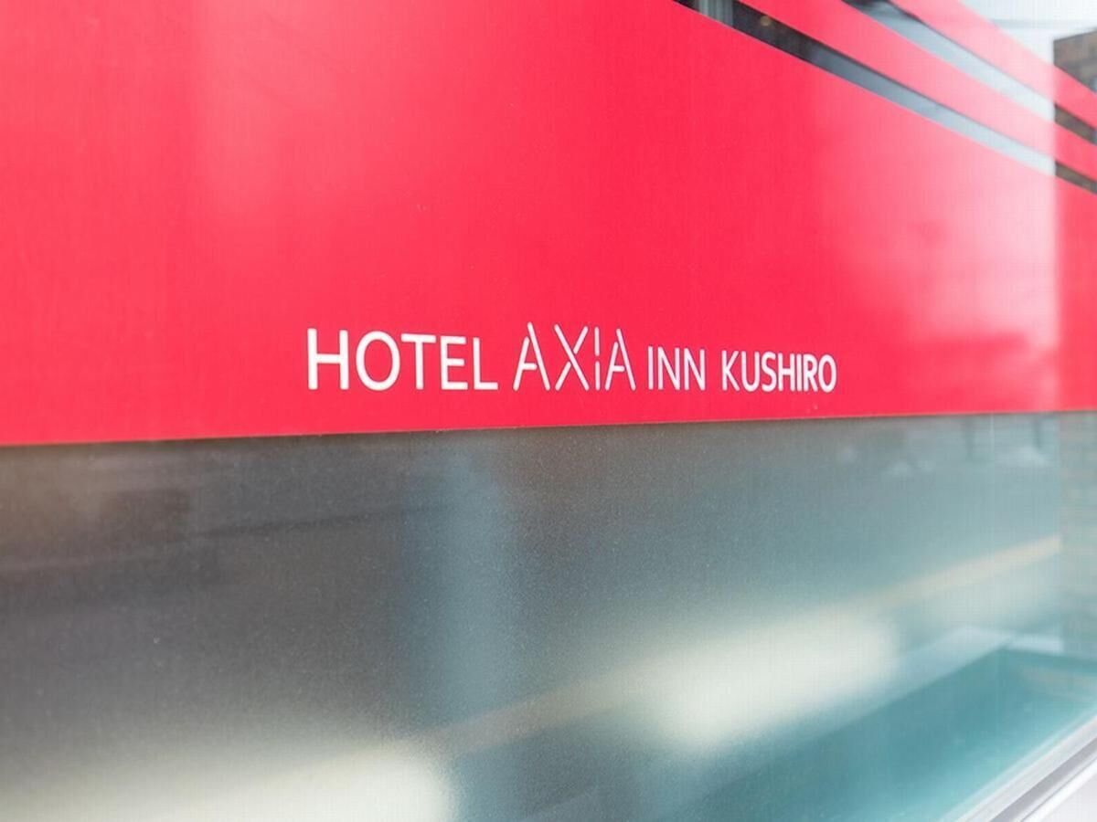 A red sign with 'HOTEL AXIA INN KUSHIRO' written on it.