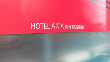 A red sign with 'HOTEL AXIA INN KUSHIRO' written on it.
