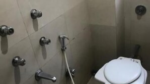 A small bathroom with a toilet, a shower, and a sink. - Sangam Guest House (Mumbai)