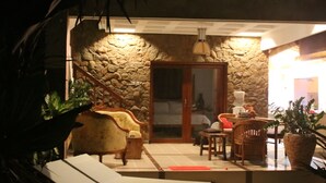 Un espace extérieur accueillant, avec des murs en pierre, une porte en bois et une plante en pot.