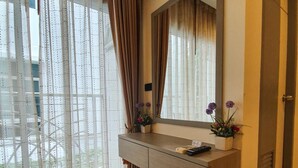 A modern bathroom with a large mirror, a vanity with a sink, and a shower area. - Parkview Ratchaprarop (Bangkok)