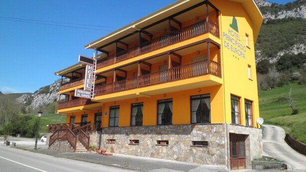 Ein zweistöckiges Hotel mit Balkonen und einer steinernen Fassade.