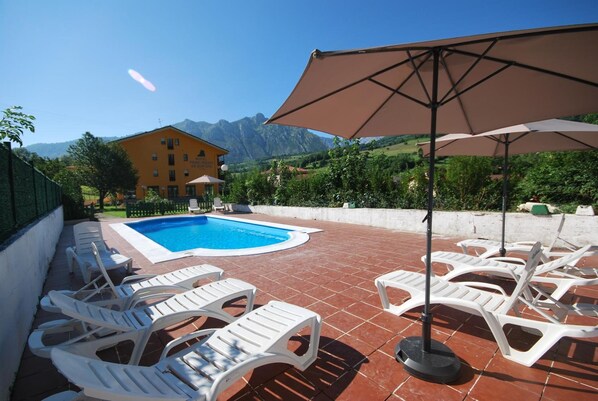 Alberca al aire libre, sombrillas en la alberca y camastros 