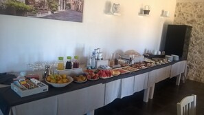 A buffet table with various food items and beverages, a coffee machine, and a decorative wall with a framed picture. - La Mela di Venere (Palazzolo Acreide)
