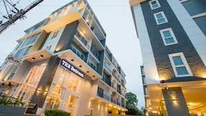 Ein mehrstöckiges Hotel mit modernem Design, mit Balkonen, großen Fenstern und einem markanten Eingang mit der Aufschrift "THE Bedroom".
