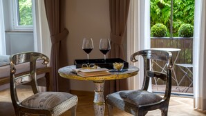 A dining area with two chairs, a small round table, and two wine glasses. - QT Suites Roma (Rome)