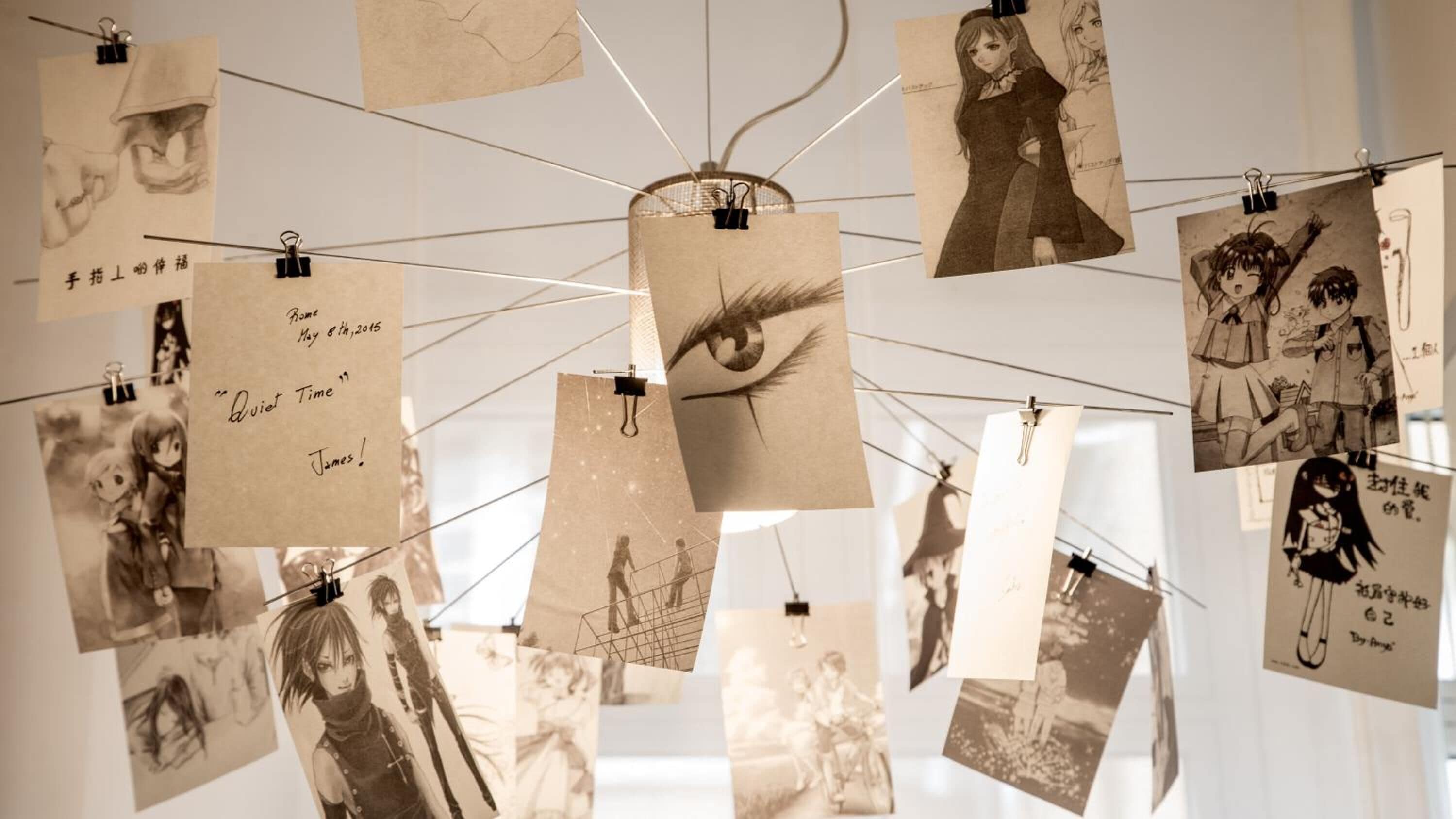 Una paret amb diverses fotografies i notes, algunes amb text i d'altres que representen escenes o personatges.