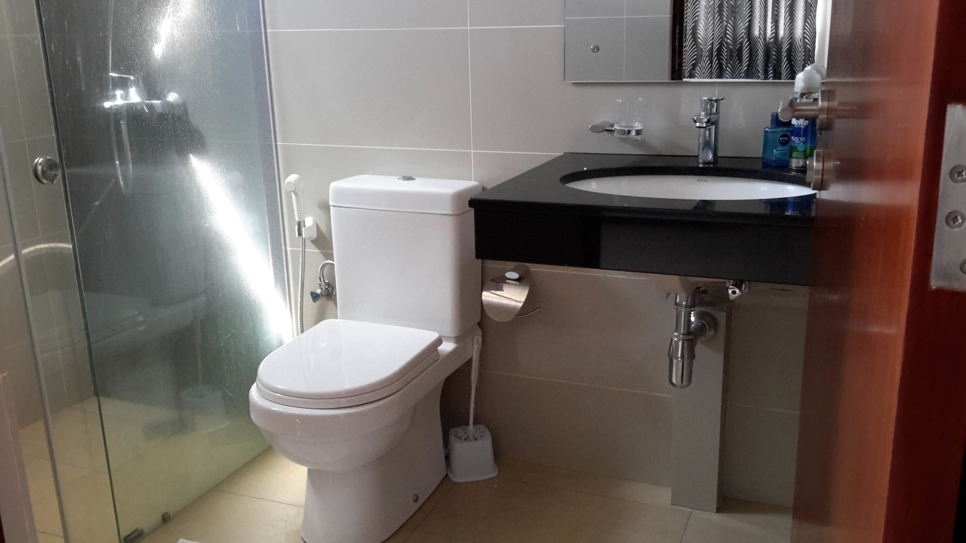 A bathroom with a toilet, a sink, and a shower.
