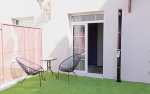 A small patio with two chairs and a table, a sliding glass door, and a white wall. - Be Mate Málaga Soho (Málaga)