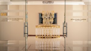 Ein modernes Interieur mit einem zentralen Kronleuchter, Glastrennsteinen und einem Schild mit der Aufschrift 'CASA HOTEL ITALIAN'.