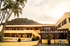 Un bâtiment à deux étages, avec une enseigne indiquant « RESTAURANT » à l’avant.