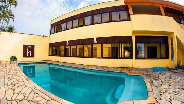 A modern two-story building with a swimming pool. - Pousada Cantinho do Mar  (Guarujá)