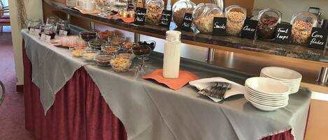 A buffet with various food items and a coffee station.