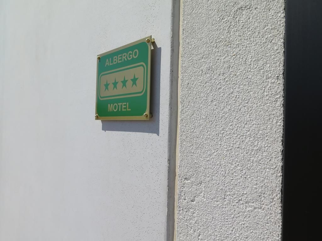 A green sign with "ALBERGO MOTEL" and three stars indicating a three-star rating.