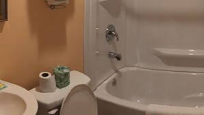 A bathroom with a toilet, a bathtub, and a towel rack with folded towels. - Travel Lite Motel (Wytheville)