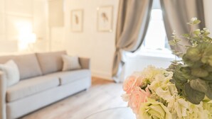 Un dormitorio moderno con cama, sofá y ventana con cortinas.