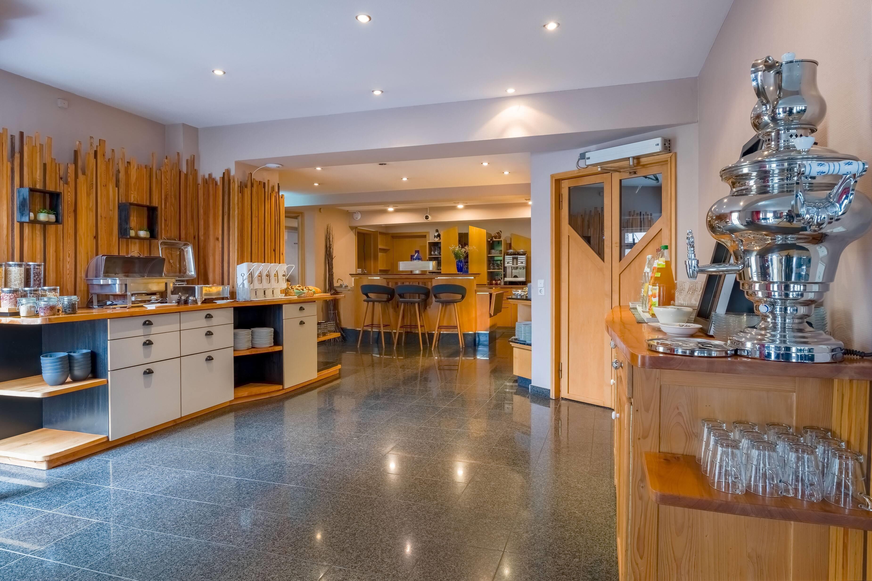 A modern kitchen with a bar area, wooden accents, and a polished floor.