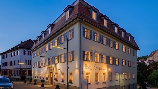 A multi-story hotel with a classic European architectural style, featuring a prominent entrance with a canopy and potted plants. - Aspire Kronprinz, Trademark Collection by Wyndham (Schwäbisch Hall)