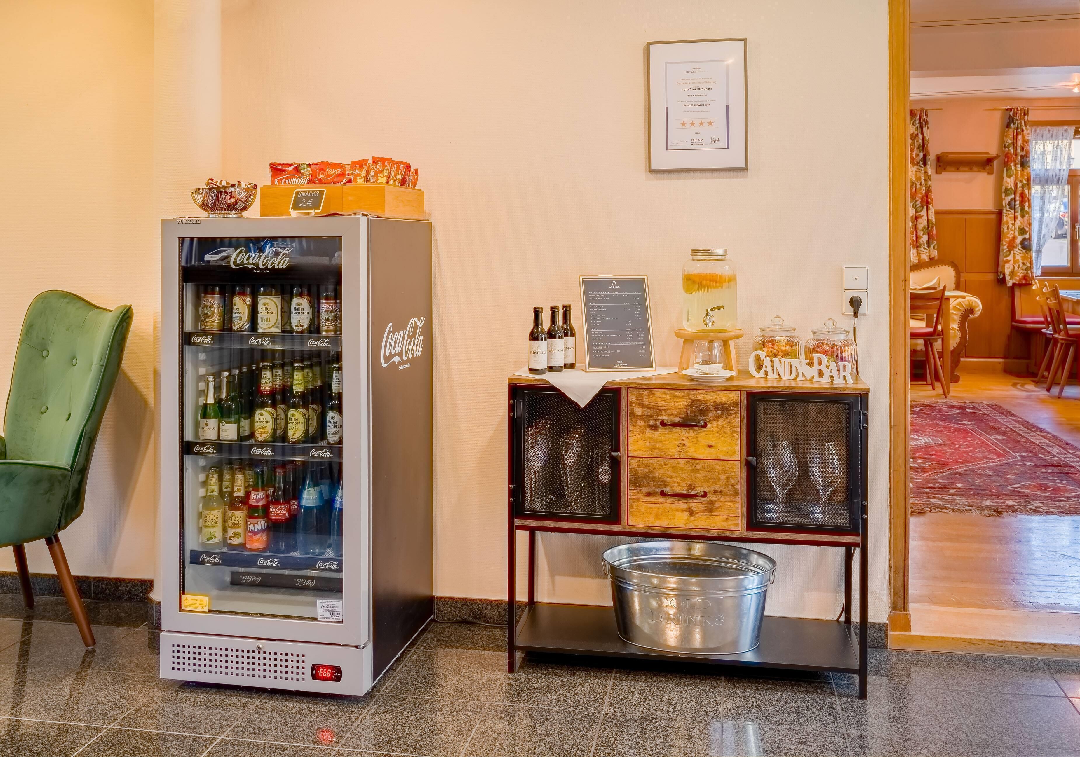 Máquina expendedora con bebidas, una barra de chocolate y un cubo sobre una mesa.