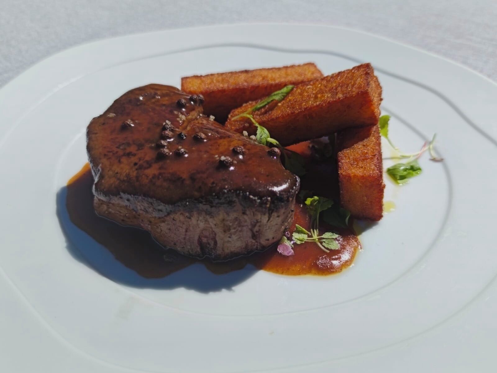 Une assiette avec un steak, des toasts et des légumes verts.