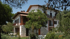 Une maison à deux étages avec une façade en pierre, un toit en tuiles et un balcon.