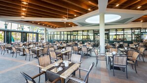 A spacious outdoor dining area with numerous tables and chairs, large windows, and a wooden ceiling. - Hotel Mediterranee Family & Spa Hotel (San Michele al Tagliamento)