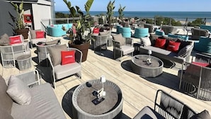A rooftop lounge with outdoor seating, including sofas and chairs, and a view of the ocean. - Hotel Mediterranee Family & Spa Hotel (San Michele al Tagliamento)