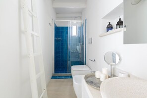 A bathroom with a shower, toilet, sink, and a mirror. - 125 Appartamento Al Bastione by Barbarhouse (Otranto)