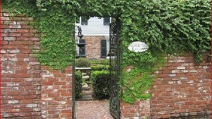 A brick gate with a sign reading "Guest & Tour Entrance." - The Burn Bed and Breakfast (Natchez)