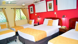 Una habitación de hotel con cuatro camas, cada una con ropa de cama blanca y amarilla, y paredes rojas.