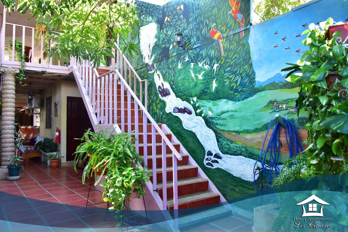 A staircase leading to a balcony with a mural of a waterfall and birds.