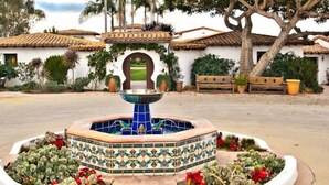 A courtyard with a fountain, surrounded by a tiled border and plants. - Casa Tropicana (San Clemente)